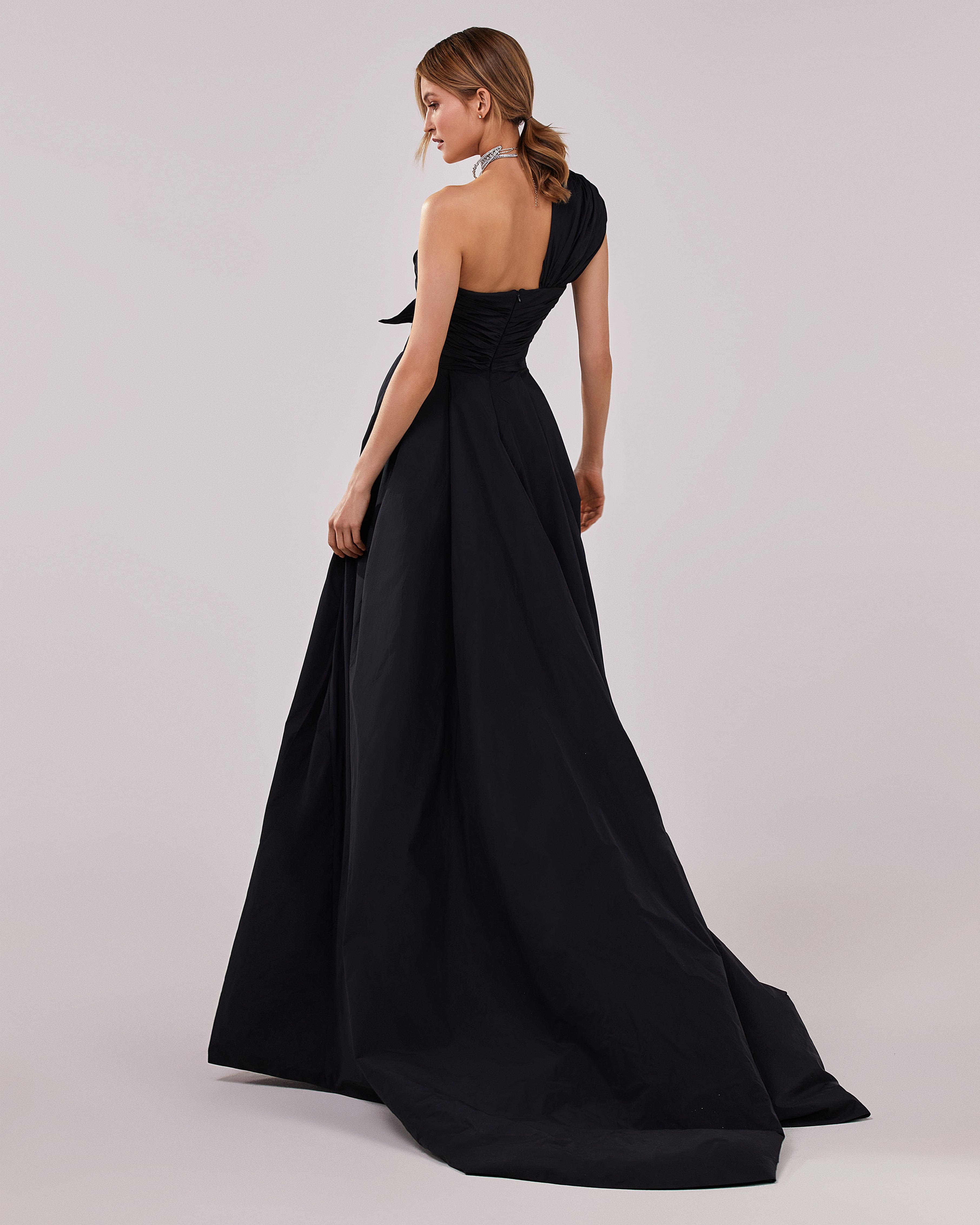 فستان سهرة أسود من قماش التفتا مع فتحة عالية وجزء علوي ملفوف بكتف واحد